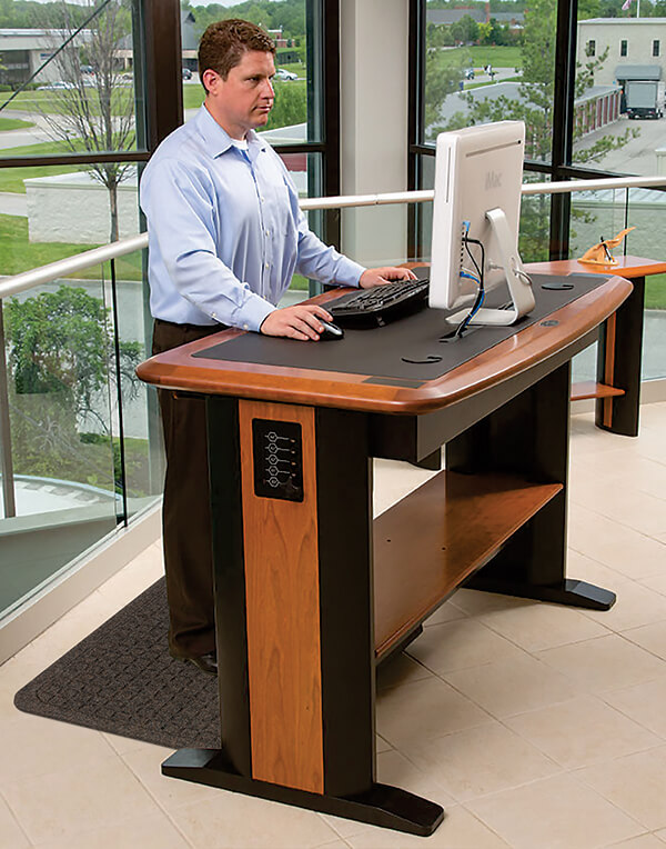 man at a standing desk with an anti-fatigue mat under his feet