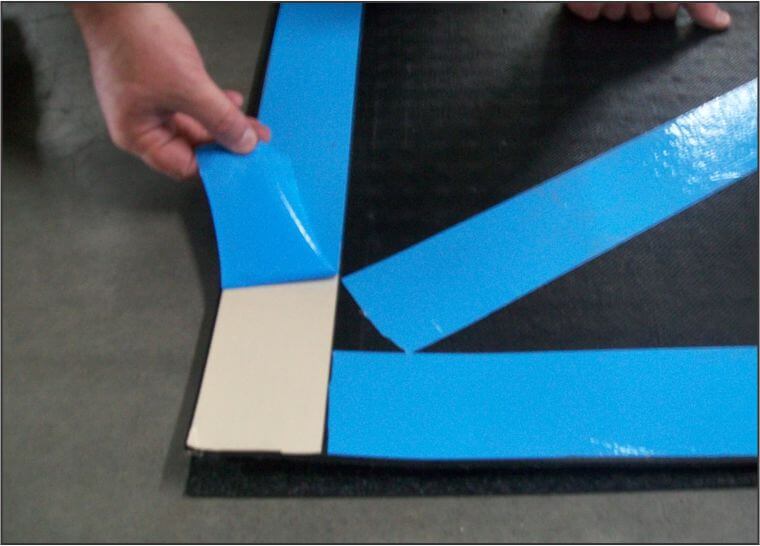person peeling away blue tape