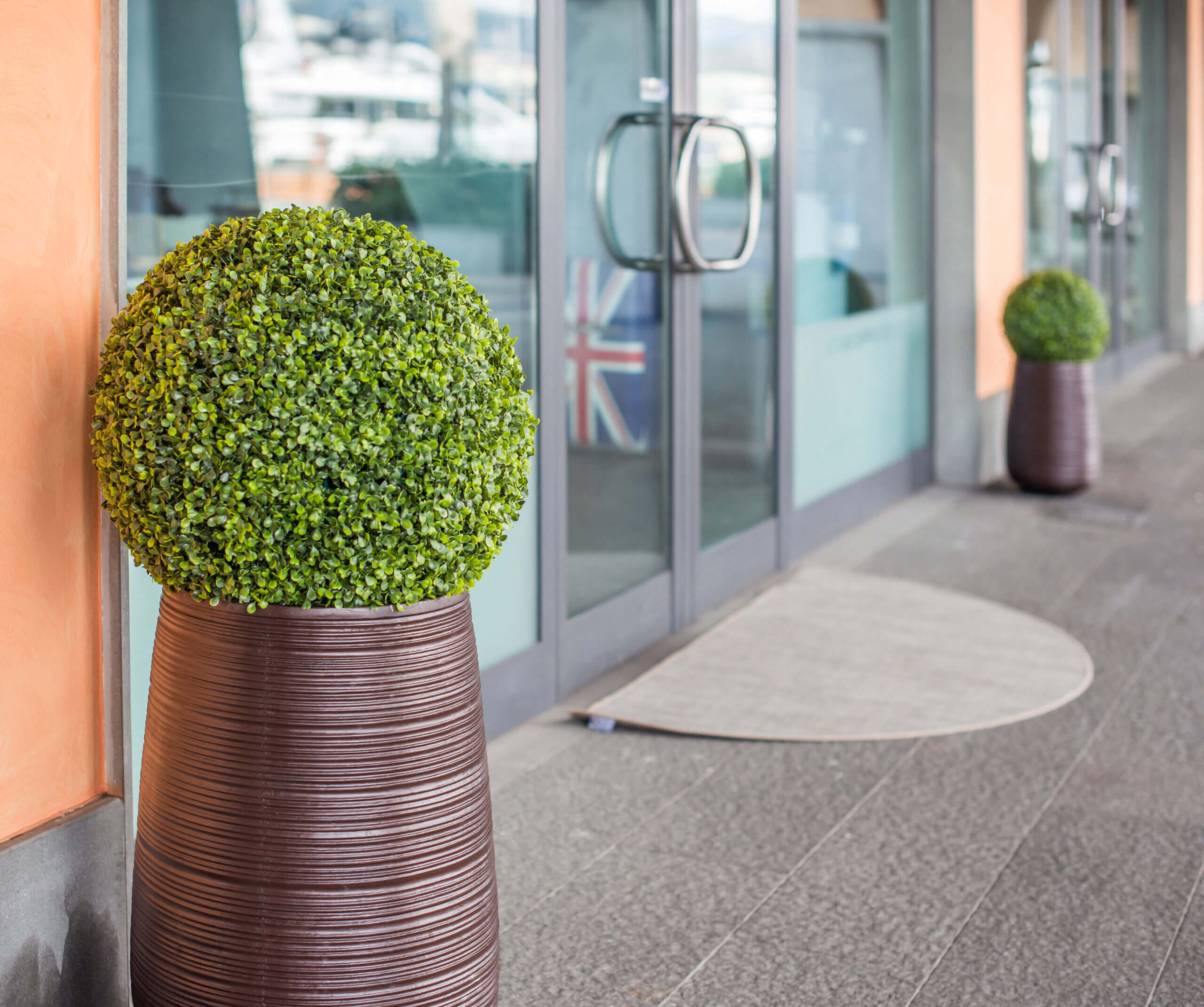 The glass door of a travel Agency. A suitcase with the British flag behind the transparent door of the office